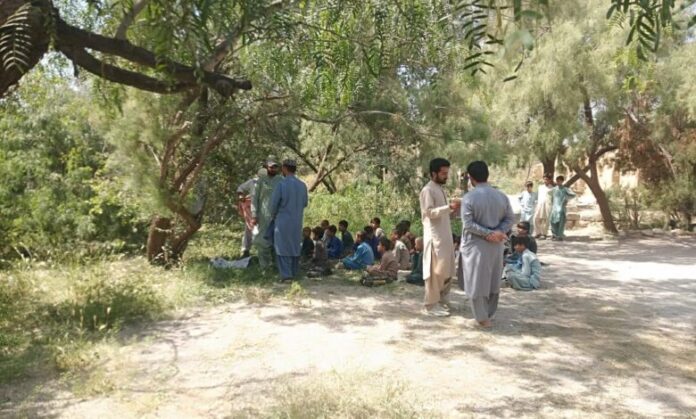 Students of Khansob middle school forced to study in open due to school destruction in floods.